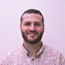 Ben Perlmutter profile image: man with beard wearing a light purple shirt with flower pattern